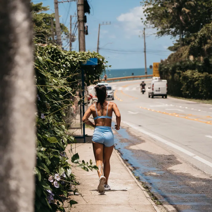 Aluna correndo a poucos metros da praia do Morro das Pedras, em Florianópolis.