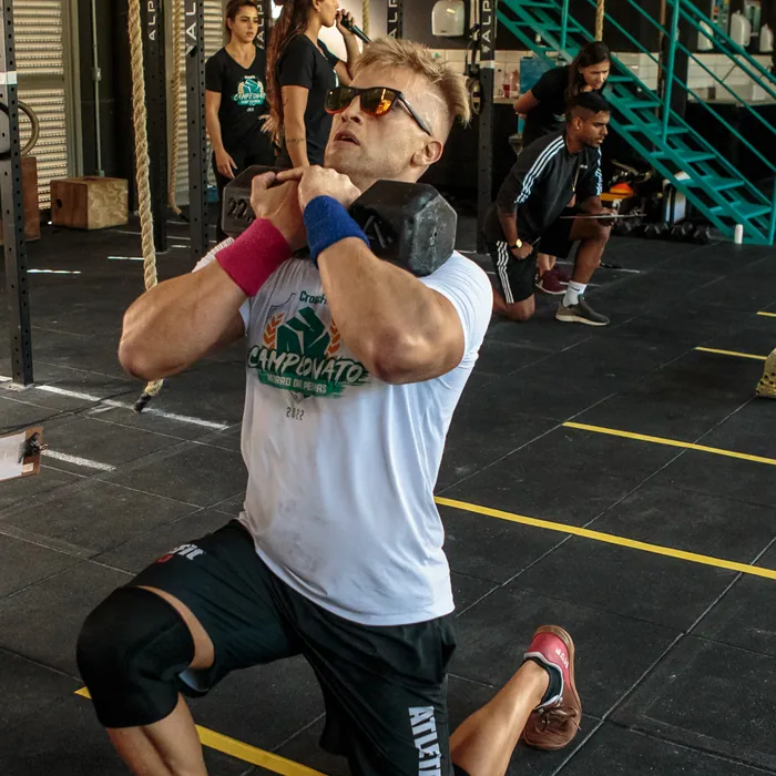 Aluno executando desenvolvimento de ombro em treino de CrossFit em Florianópolis.