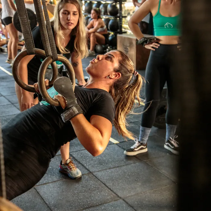 Aluna treinando nas argolas dentro do box do CrossFit Morro das Pedras.