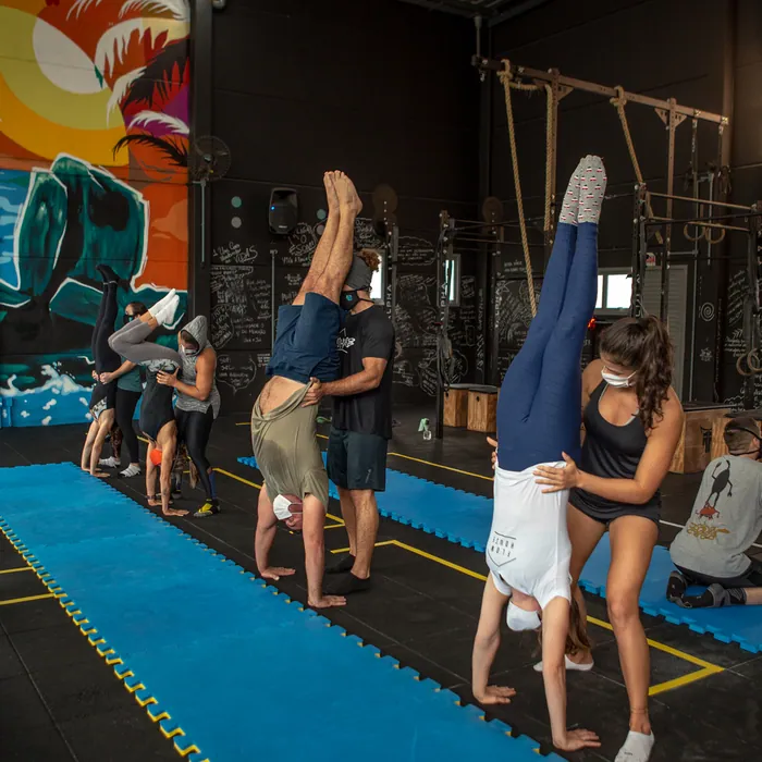 Alunos treinando parada de mão na aula de ginástica do CrossFit Morro das Pedras.